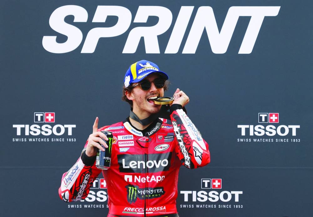 Francesco Bagnaia celebrates on a podium after winning the sprint race. (Reuters)