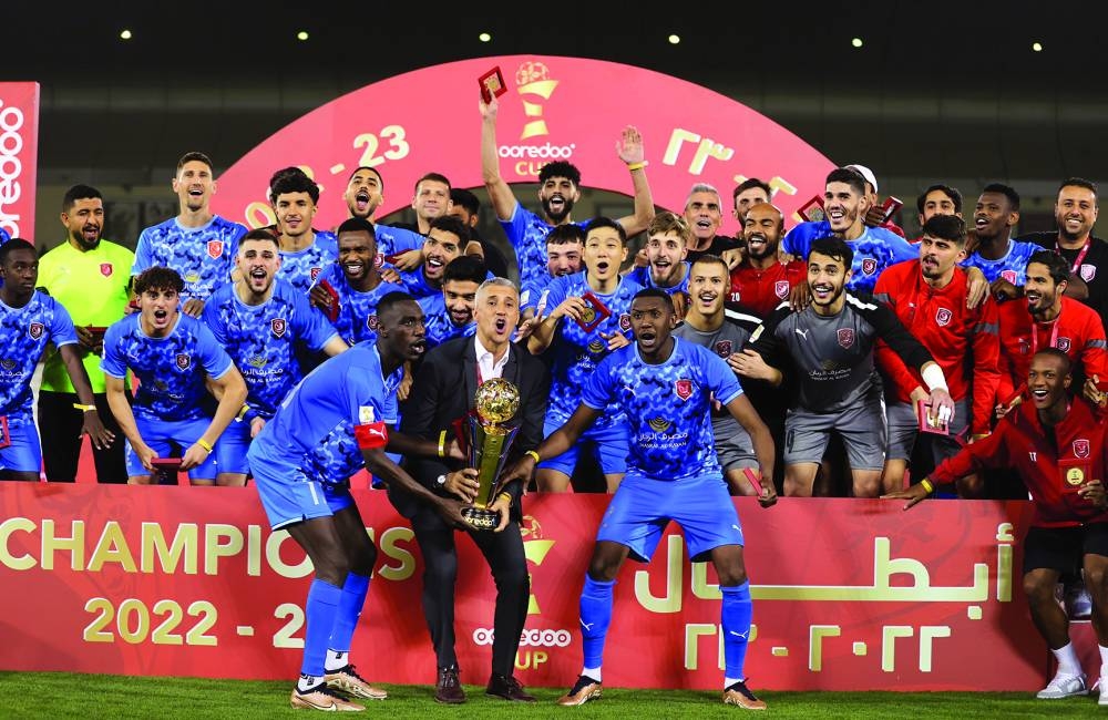 Al Duhail players and head coach Hernan Crespo celebrate with the trophy after winning the Ooredoo Cup at the Jassim Bin Hamad Stadium on Tuesday night.