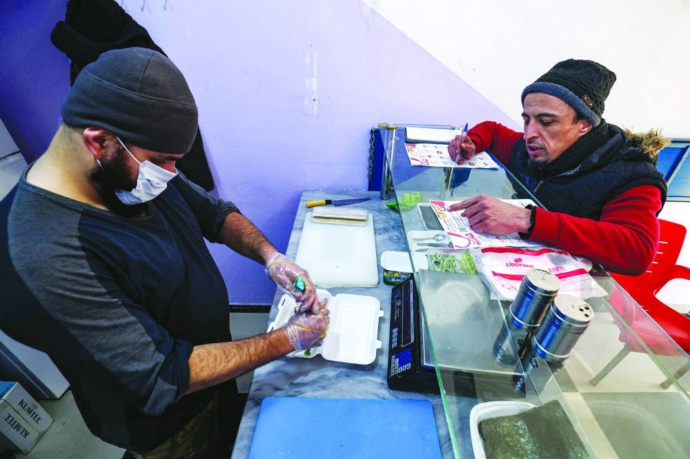 Islam Shakhbanov observes as his staff prepares rolls at his sushi restaurant in Syria’s rebel-held northwestern city of Idlib.