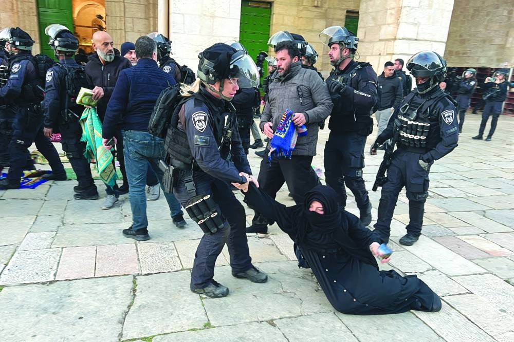 Israeli security forces remove a Palestinian Muslim woman sitting on the grounds of the Al-Aqsa mosque compound in Jerusalem during Ramadan yesterday. (AFP)