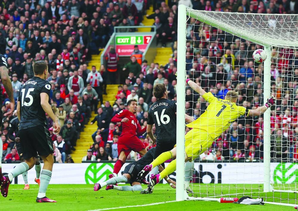 Liverpool’s Roberto Firmino scores their second goal against Arsenal during their Premier League match in Liverpool yesterday. (Reuters)