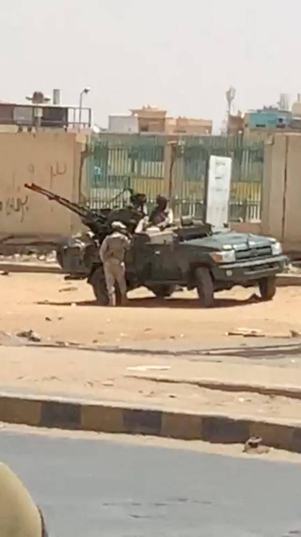 A military vehicle and soldiers are seen on a street of Khartoum, Sudan, in this scren grab obtained from a social media video. Mohammadkhair Abdualrhman/via REUTERS  