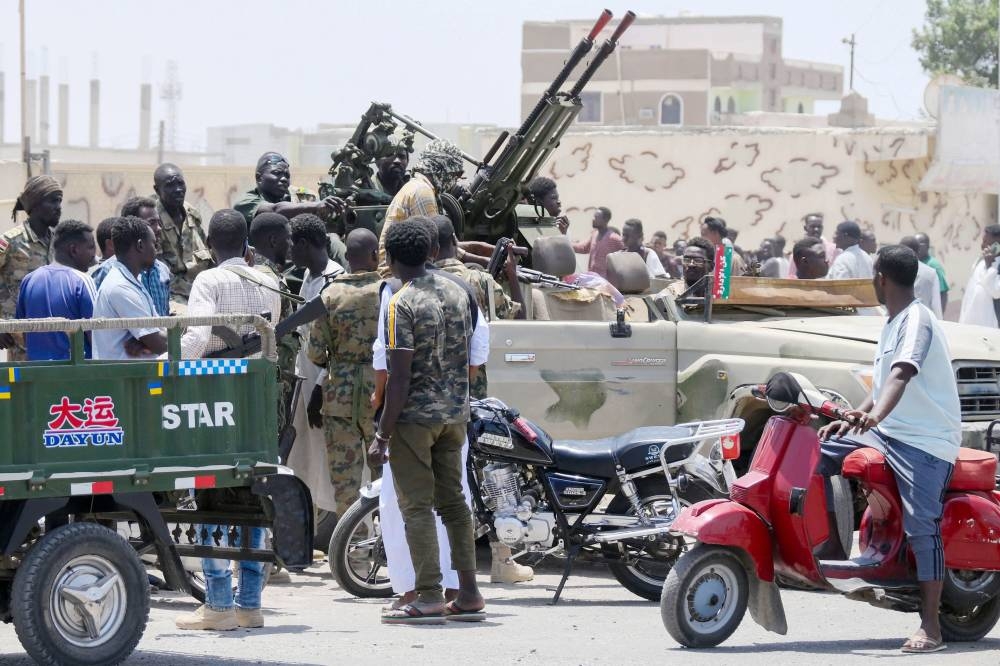 Sudanese greet army soldiers, loyal to army chief Abdel Fattah al-Burhan, in the Red Sea city of Port Sudan on April 16.  AFP
