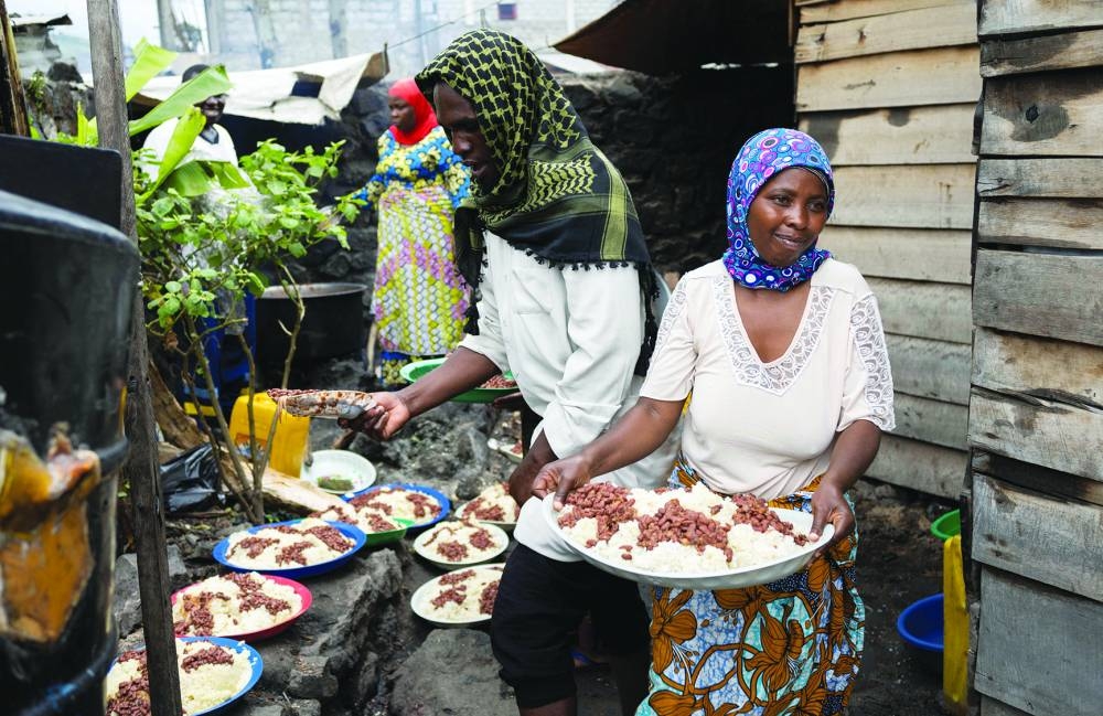 Internally displaced Congolese share a meal during Eid al-Fitr celebrations in the Munigi camp site near Goma in the North Kivu province of the Democratic Republic of Congo.