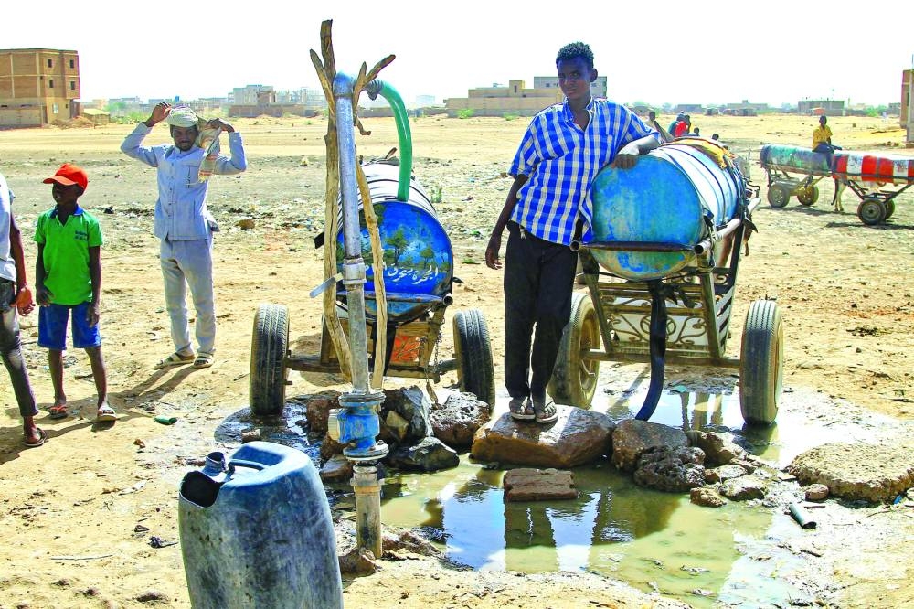 People fill barrels with water in southern Khartoum yesterday, amid water shortages caused by ongoing battles between the forces of two rival Sudanese general.