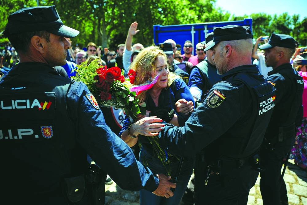 A supporter of the founder of the Spanish fascist Falange party scuffles with police officers outside Madrid’s San Isidro cemetery.