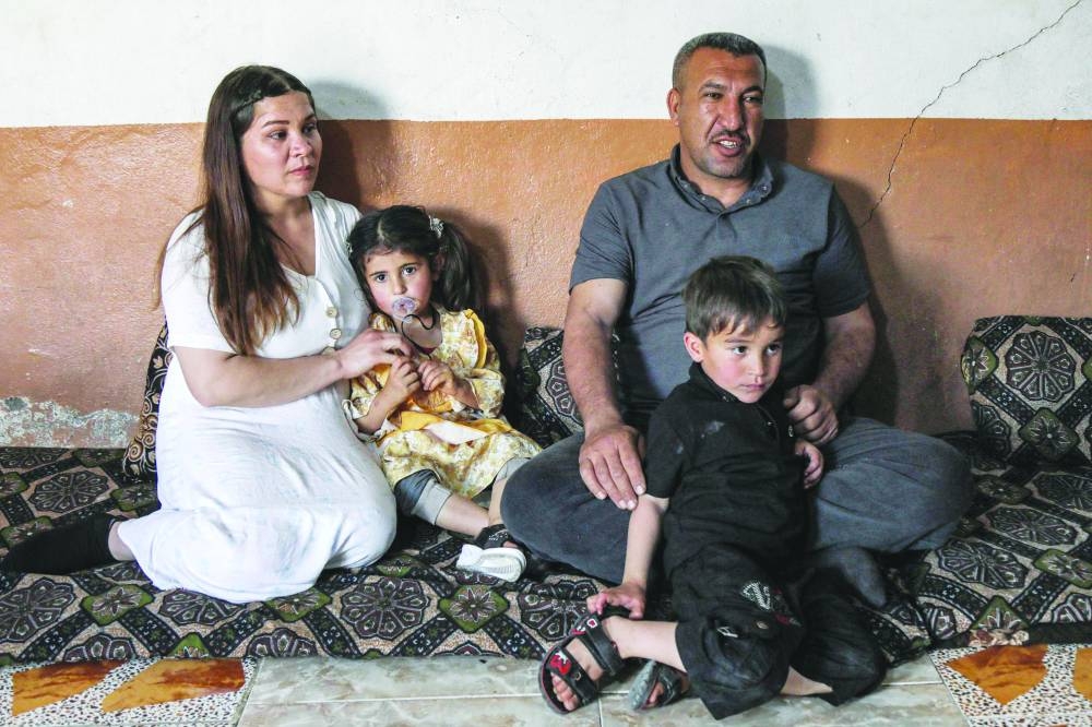 In this picture taken on April 19, 2023, Hayam (left), a 26-year-old displaced Iraqi woman from the Yazidi community, gives an interview with her husband Marwan and children in a home in the region of Sharya, near the northern Iraqi city of Dohuk.