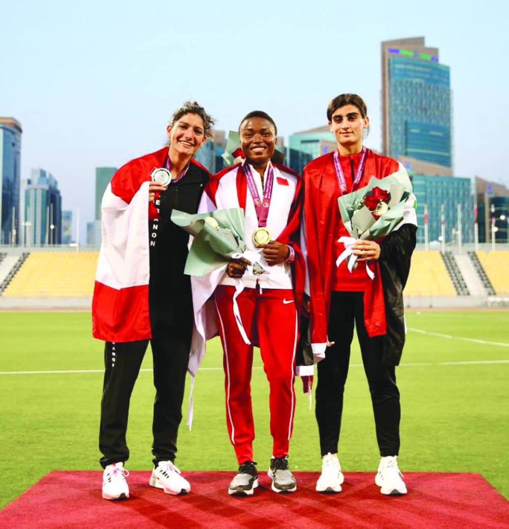 Women’s long jump medallists celebrate on the podium.