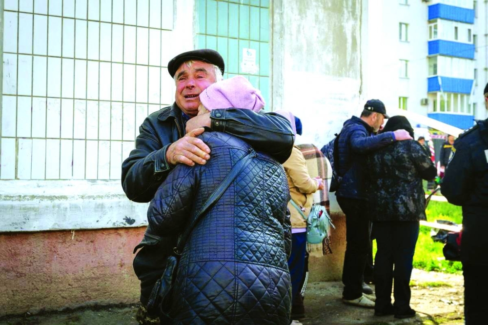 Relatives of victims grieve at a site of a residential building heavily damaged by a Russian missile strike in the town of Uman. (Reuters) 