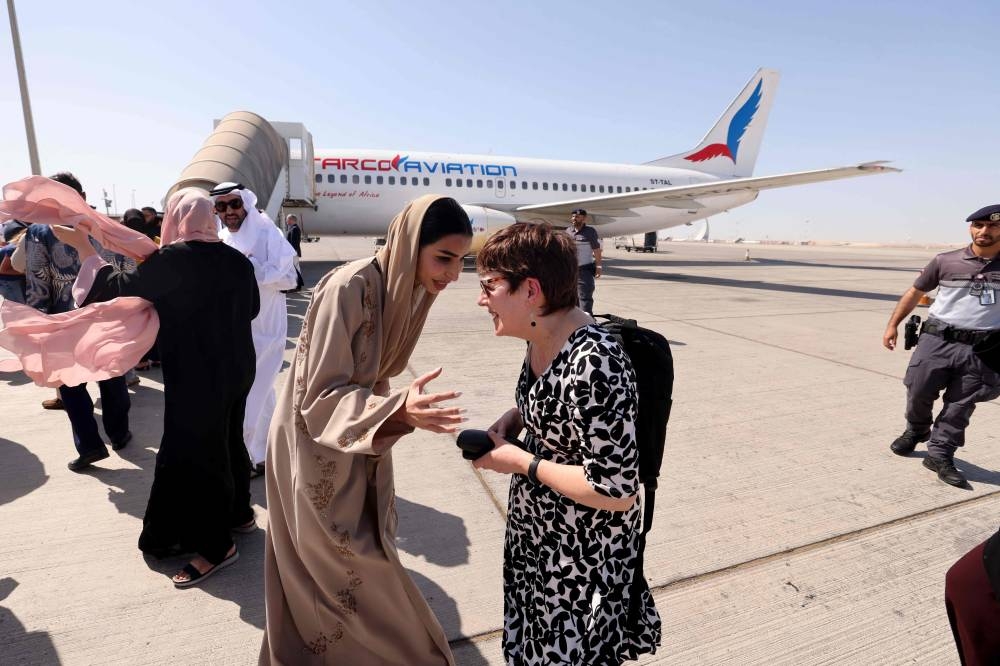 Officials wait for the disembarkment of evacuees from Sudan at an airport in Abu Dhabi, after an evacuation flight.  AFP