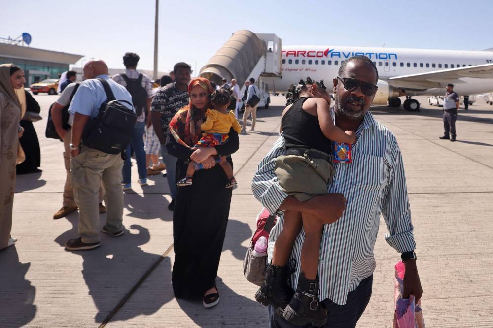 People fleeing conflict in Sudan are welcomed by Emirati officials at an airport in Abu Dhabi after an evacuation flight. AFP