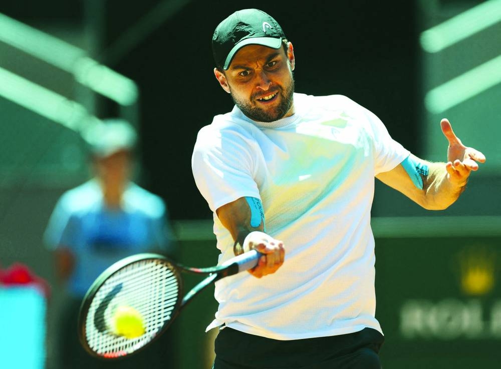 Russia's Aslan Karatsev returns the ball to China's Zhang Zhizhen during their 2023 ATP Tour Madrid Open quarter-final on Thursday. (AFP)