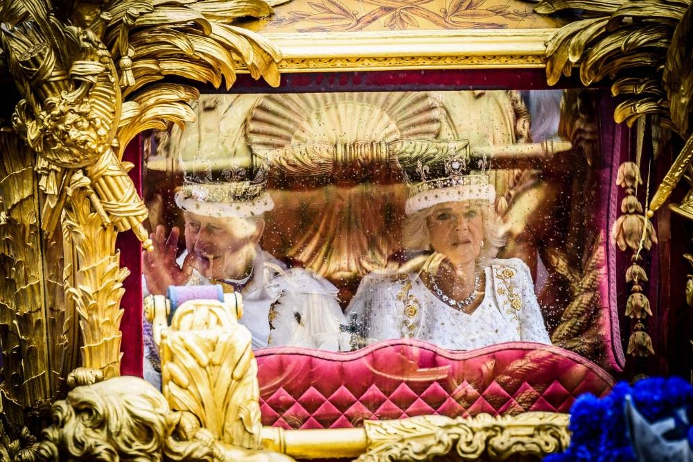Britain's King Charles III and Britain's Queen Camilla begin their journey in the Gold State Coach, in the 'King's Procession', a journey of two kilometres from Buckingham Palace to Westminster Abbey in central London on May 6, 2023, ahead of their coronations. - The set-piece coronation is the first in Britain in 70 years, and only the second in history to be televised. Charles will be the 40th reigning monarch to be crowned at the central London church since King William I in 1066. Outside the UK, he is also king of 14 other Commonwealth countries, including Australia, Canada and New Zealand. Camilla, his second wife, will be crowned queen alongside him and be known as Queen Camilla after the ceremony. AFP