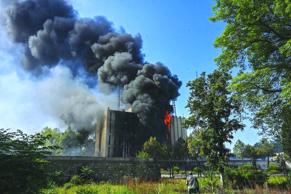 Black smokes billows from a building set ablaze by Pakistan Tehreek-e-Insaf (PTI) party activists and supporters of former Pakistan prime minister Imran Khan during a protest against the arrest of their leader, in Peshawar, yesterday.