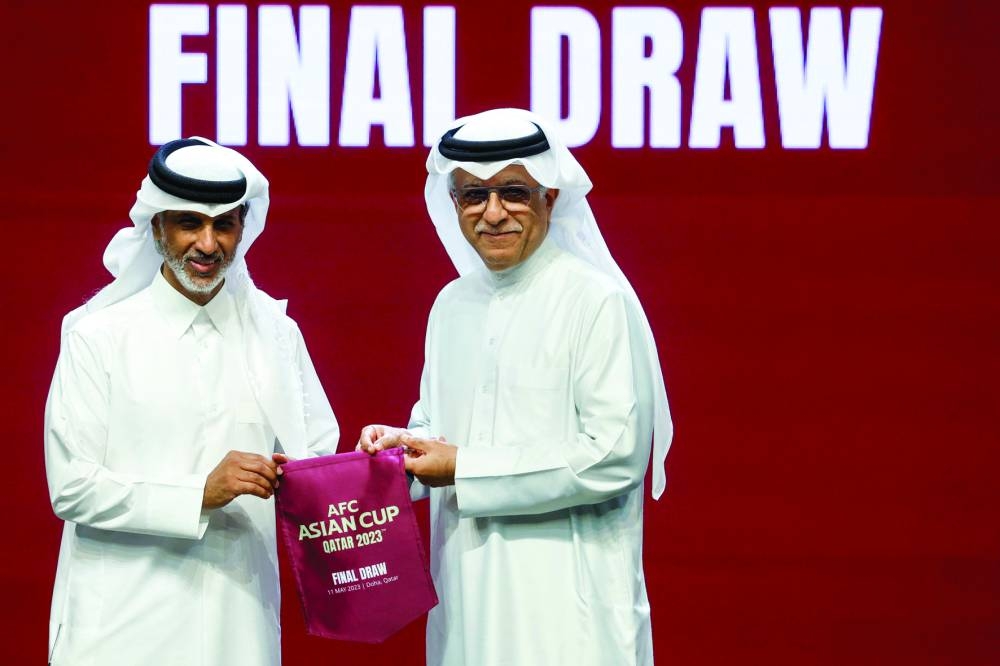 Qatar Football Association’s president Sheikh Hamad bin Khalifa bin Ahmed al-Thani (left) and President of the Asian Football 
Confederation Sheikh Salman bin Ibrahim al-Khalifa pose during the AFC Asian Cup draw ceremony in Doha on Thursday. (AFP)
