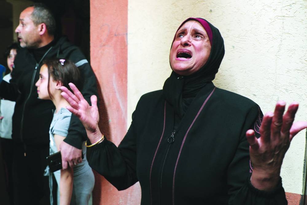 
A Palestinian woman reacts following an Israeli strike on an apartment in Gaza. 