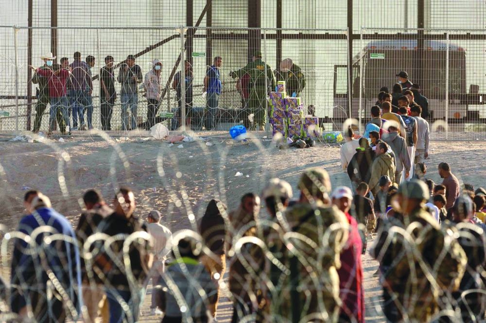 
Immigrants wait to be transported and processed by US Border Patrol agents at the US-Mexico border in El Paso, Texas. 