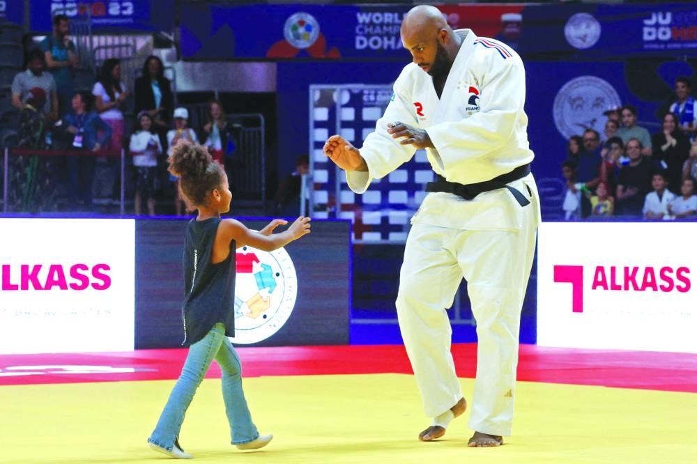 France’s Teddy Riner plays with his daughter after winning the men’s +100Kg gold at the World Judo Championship Doha 2023 on Saturday. (AFP)