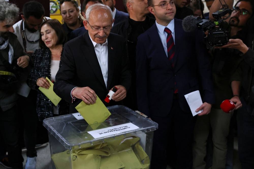 Kemal Kilicdaroglu, presidential candidate of Turkiye's main opposition alliance, casts a ballot during the presidential and parliamentary elections next to his wife Selvi Kilicdaroglu, at a polling station in Ankara. REUTERS/Yves Herman
