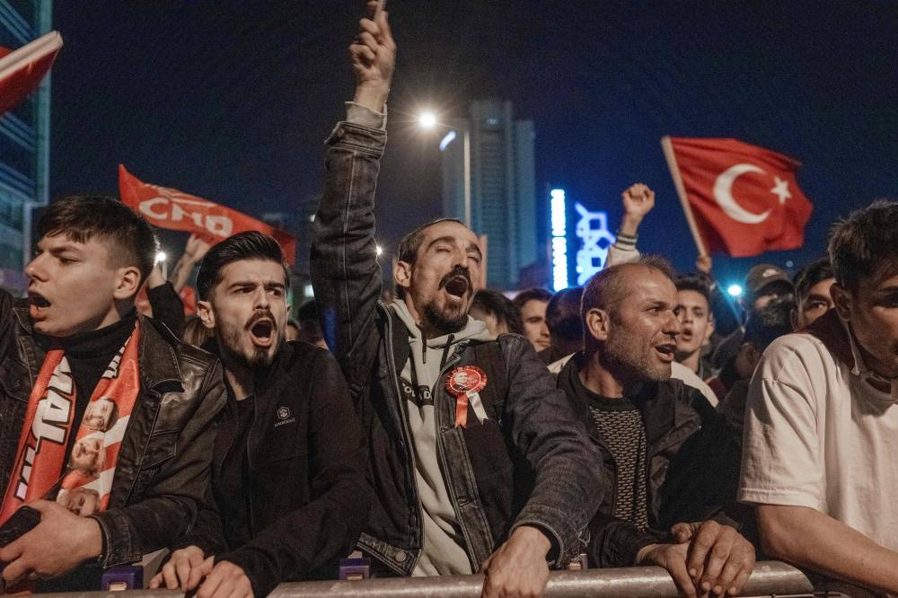 Supporters of Turkey's Republican People's Party (CHP) Chairman and presidential candidate Kemal Kilicdaroglu chant slogans outside CHP headquarters in Ankara. BULENT KILIC / AFP