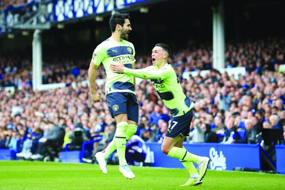 Manchester City’s Ilkay Gundogan (left) celebrates with teammate Phil Foden after scoring his team’s third goal during the English Premier League match against Everton in Liverpool yesterday. (AFP)