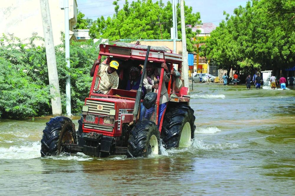 People ride on a tractor on the submerged road in Beledweyne, central Somalia, yesterday.