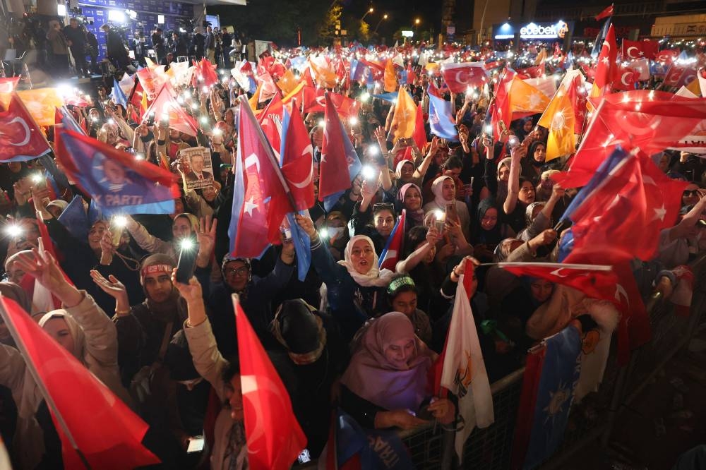 Supporters of Turkish President Tayyip Erdogan wave flags outside the AK Party headquarters after polls closed in Turkiye's presidential and parliamentary elections in Ankara. Adem ALTAN / AFP