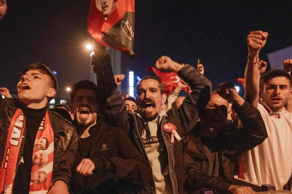 Supporters of Turkiey's Republican People's Party (CHP) Chairman and presidential candidate Kemal Kilicdaroglu chant slogans outside CHP headquarters in Ankara. BULENT KILIC / AFP