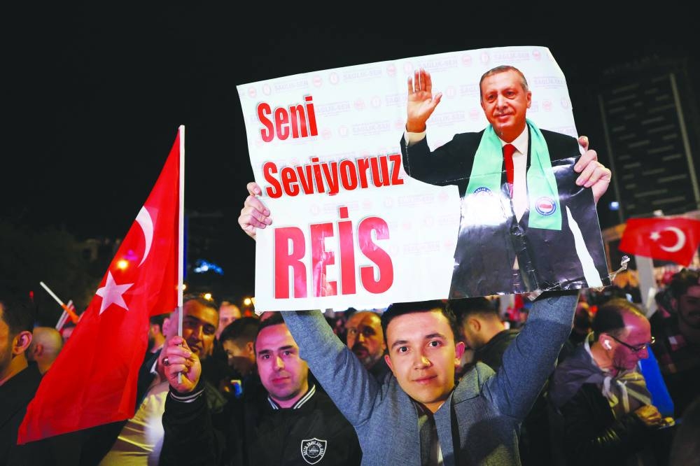 A supporter of Turkish President Tayyip Erdogan holds a poster which reads "We Love You Chief" outside the AK Party headquarters after polls closed in Turkey's presidental and parliamentary elections in Ankara. Adem ALTAN / AFP