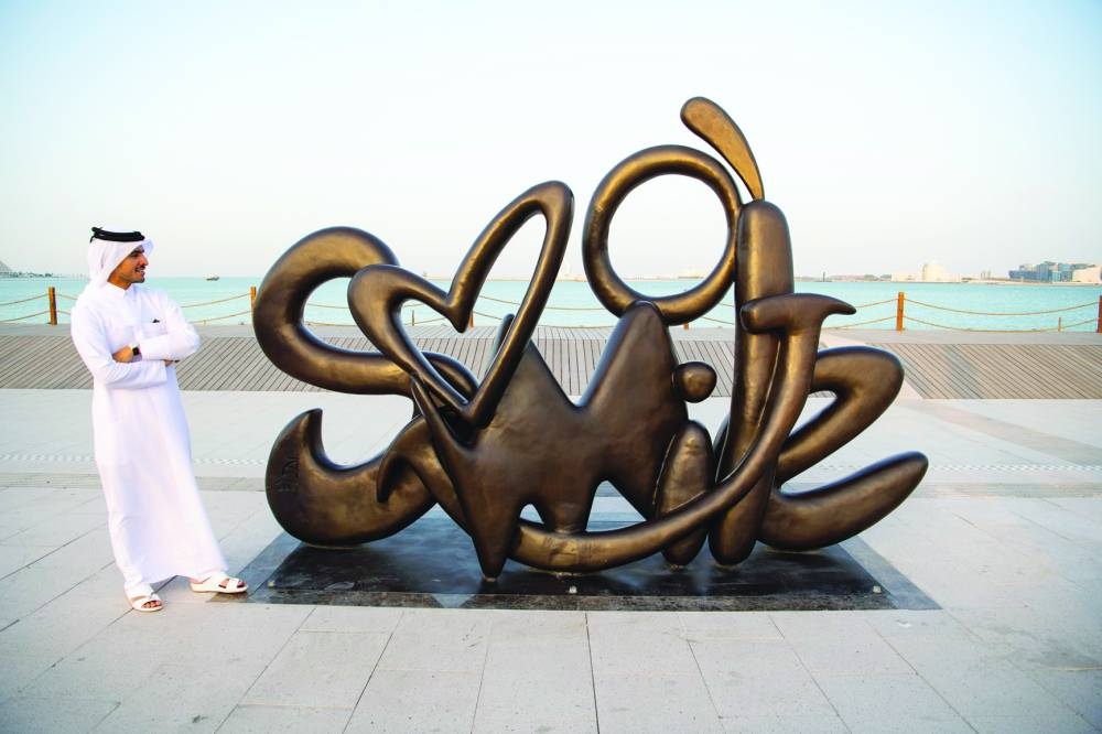  Qatari artist Ahmed al-Maadheed with his artwork 'Smile' installed on the Doha Corniche.