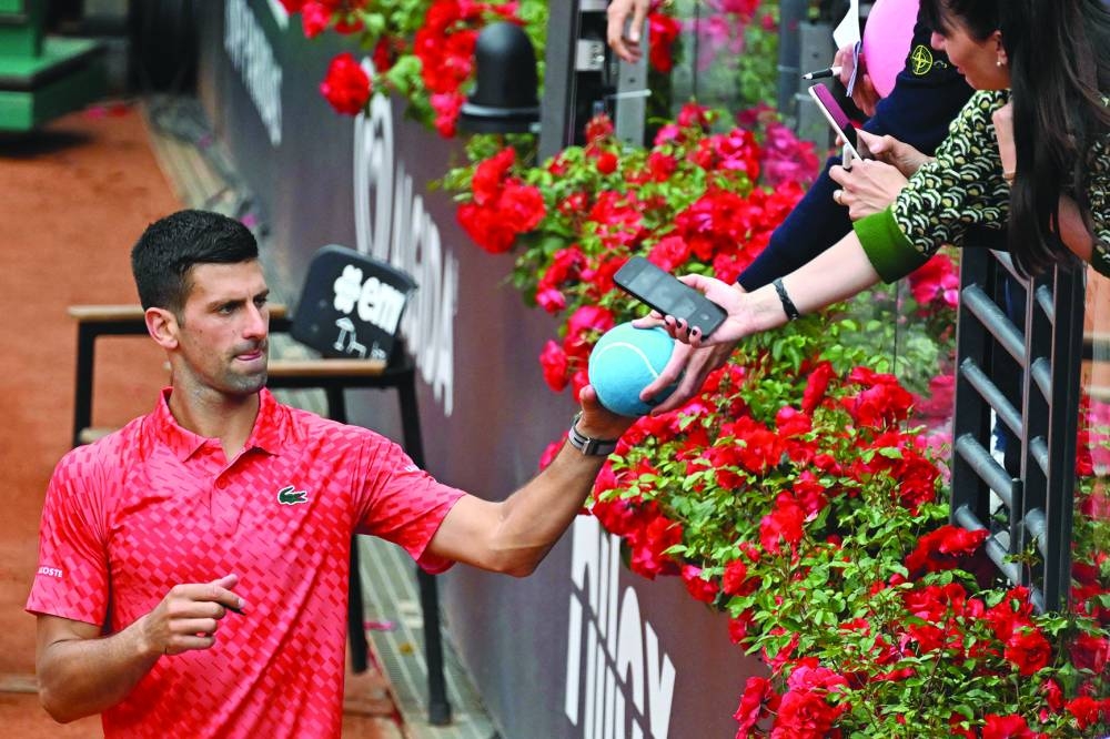 Serbia's Novak Djokovic signs autographs after defeating Britain's Cameron Norrie in their fourth round match of the ATP Rome Open at Foro Italico on Tuesday. (AFP)