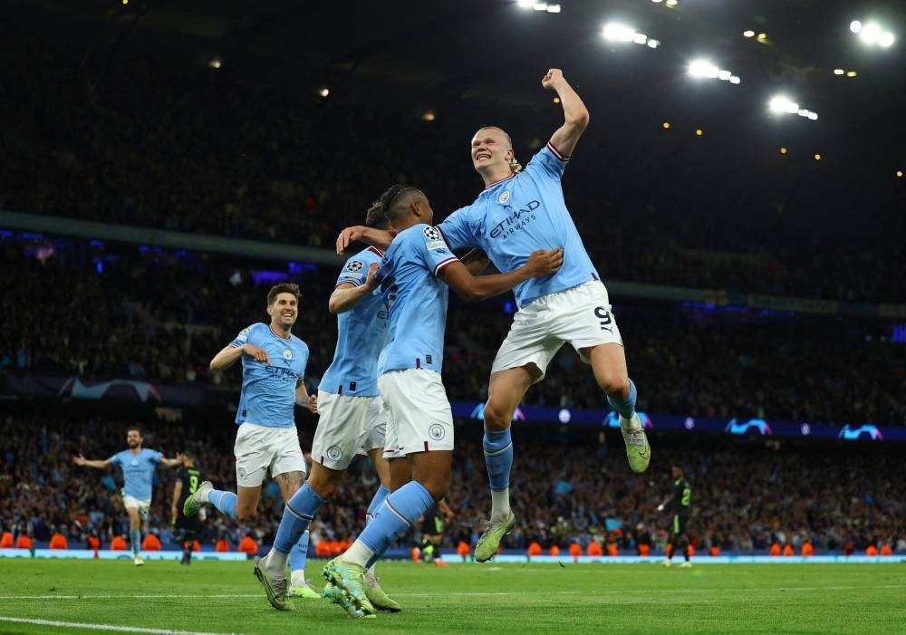 Manchester City's John Stones, Erling Braut Haaland, Manuel Akanji and Ruben Dias celebrate their third goal an own goal scored by Real Madrid's Eder Militao, on Wednesday. (Reuters)
