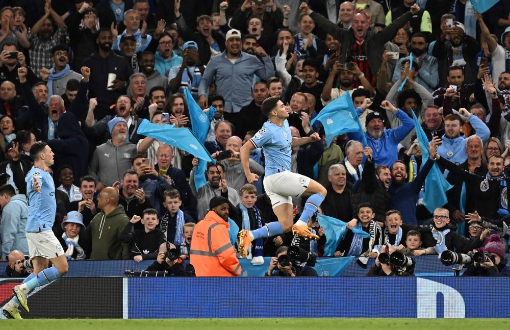 Manchester City's Argentinian striker Julian Alvarez (right) celebrates scoring the team's fourth goal with Manchester City's English midfielder Phil Foden during the UEFA Champions League second leg semi-final football match between Manchester City and Real Madrid at the Etihad Stadium in Manchester, north west England, on Wednesday. (AFP)