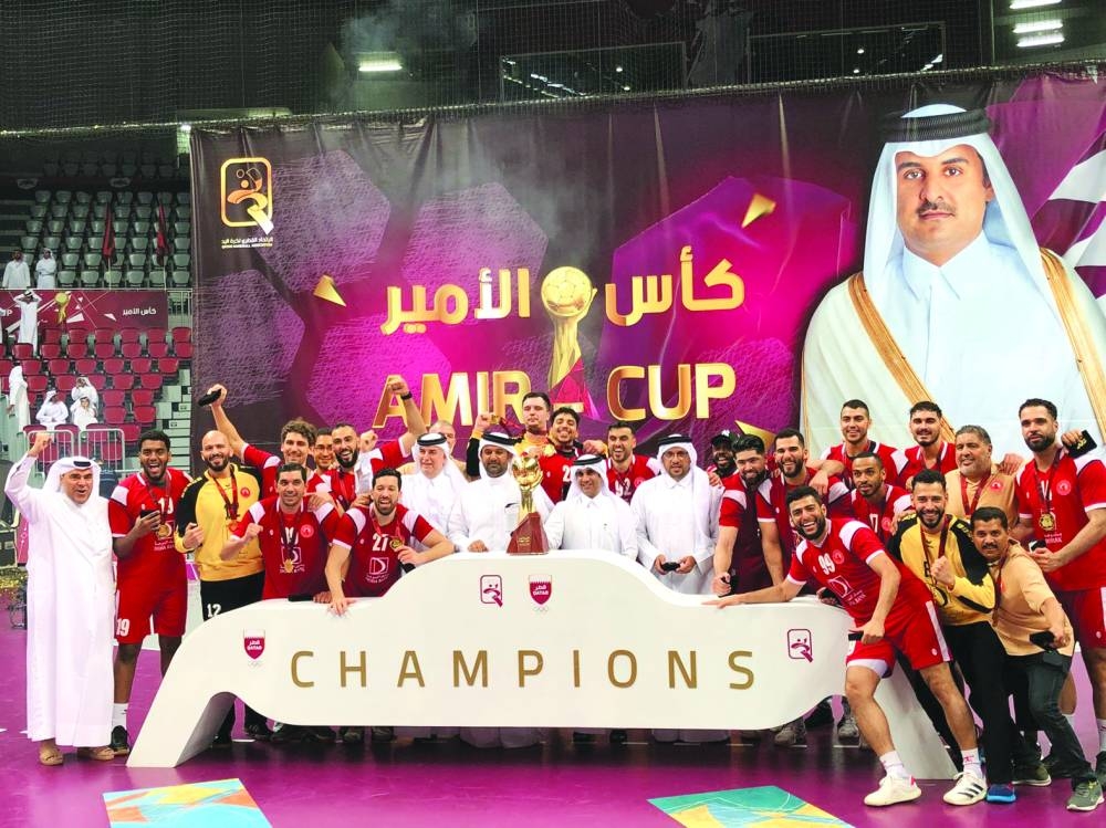 Al Arabi players and staff celebrate after winning the Amir Cup handball title for the third time.