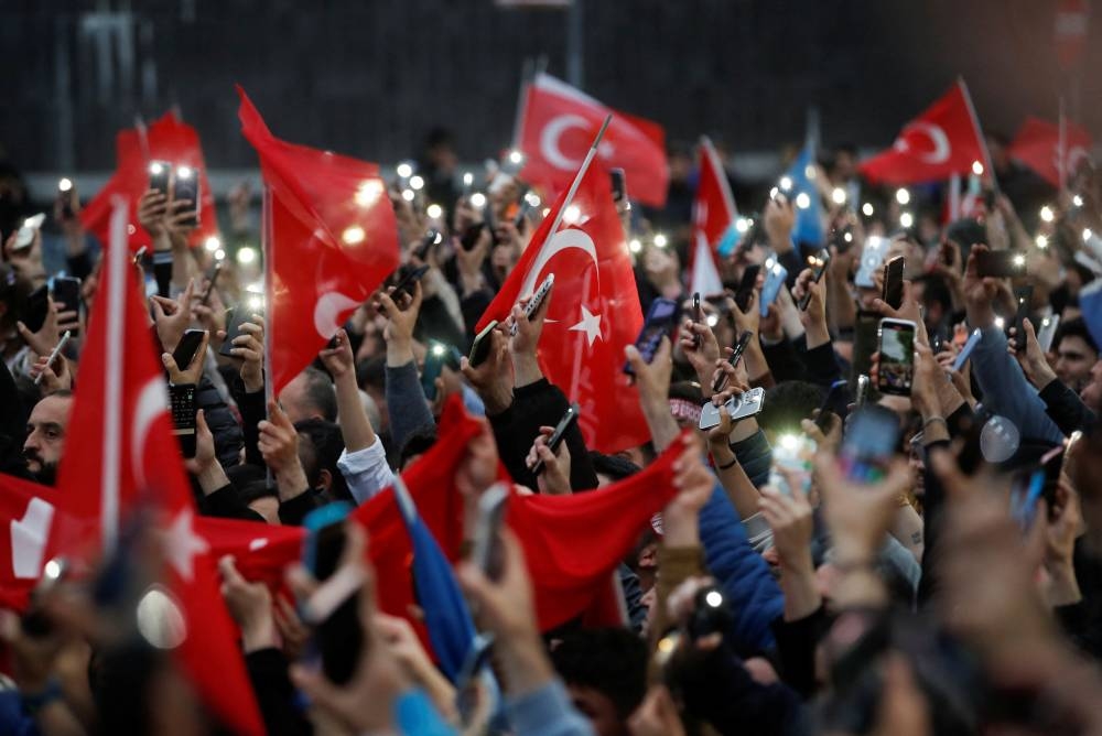 Supporters of Turkish President Tayyip Erdogan wait for his address following early exit poll results for the second round of the presidential election in Istanbul.
