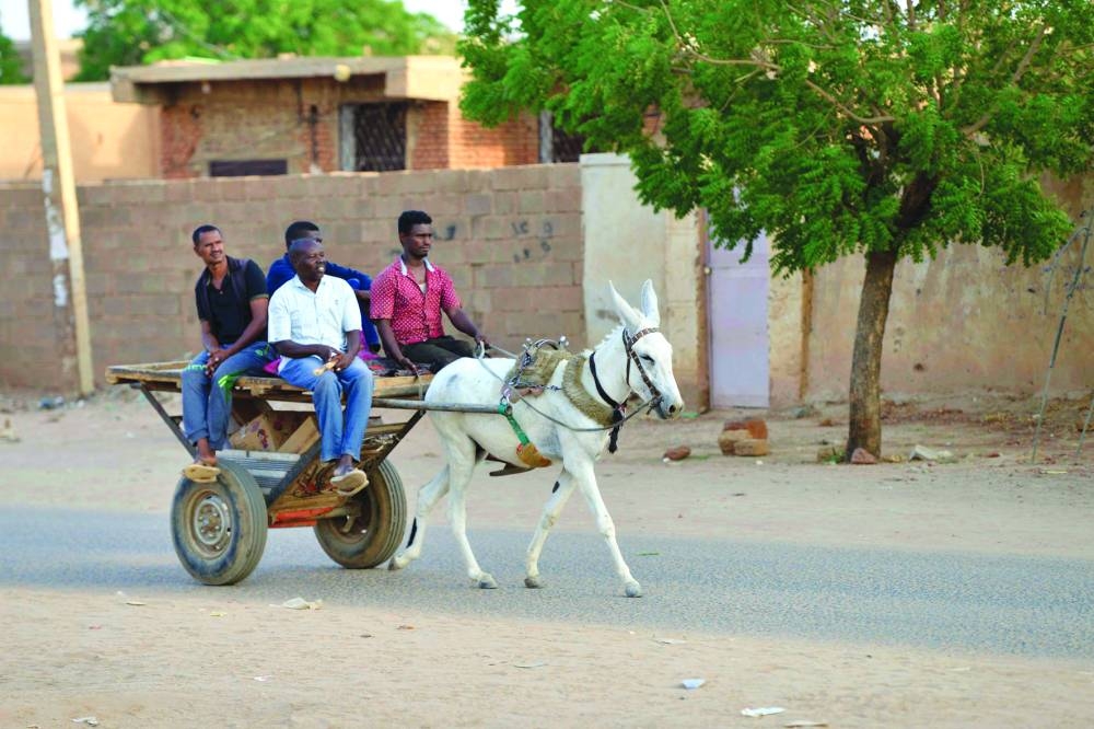 People ride a donkey-pulled cart along a street in Omdurman, Khartoum’s twin city, on Sunday.