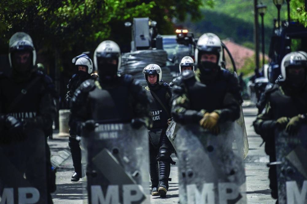 Nato soldiers and International military police secure the area near Zvecan, northern Kosovo on Tuesday, a day following clashes with Serb protesters demanding the removal of recently elected Albanian mayors. (AFP)