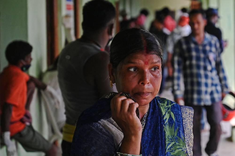 A lady looks for her relative's body at a high school used as temporary mortuary to identify the dead recovered from a carriage wreckage of a three-train collision near Balasore, in India's eastern state of Odisha. DIBYANGSHU SARKAR / AFP