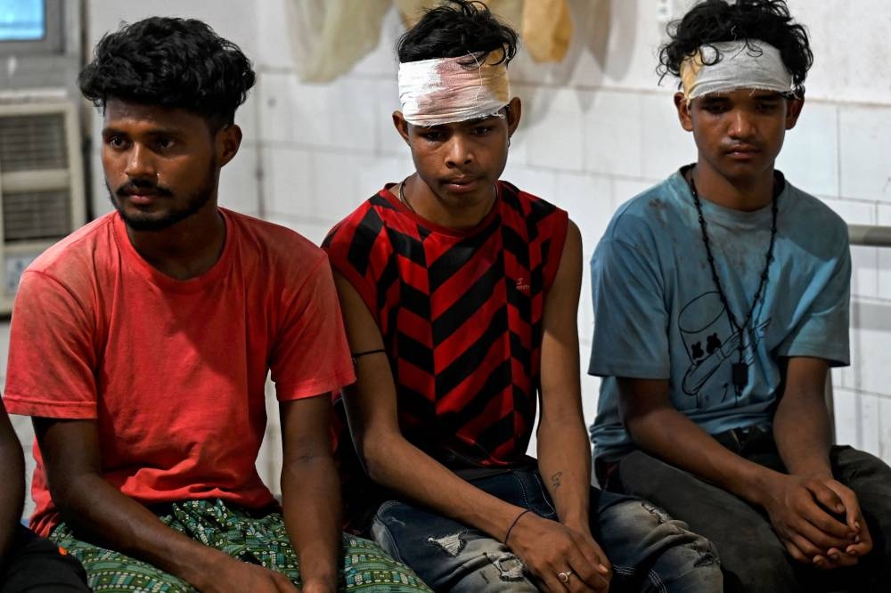 Wounded survivors rescued from a carriage wreckage of a three-train collision near Balasore, sit at the Soro government hospital in India's eastern state of Odish. Punit PARANJPE / AFP