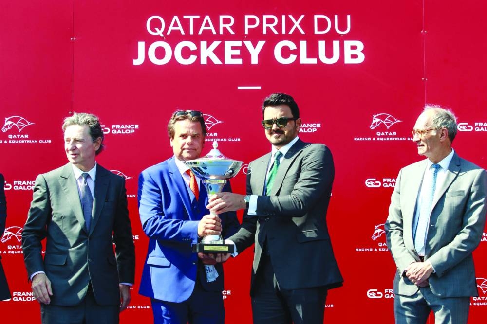 HE Sheikh Joaan bin Hamad al-Thani, President of the Qatar Olympic Committee, poses with the connections of Qatar Prix du Jockey Club winner Ace Impact at Chantilly, France, on Sunday.