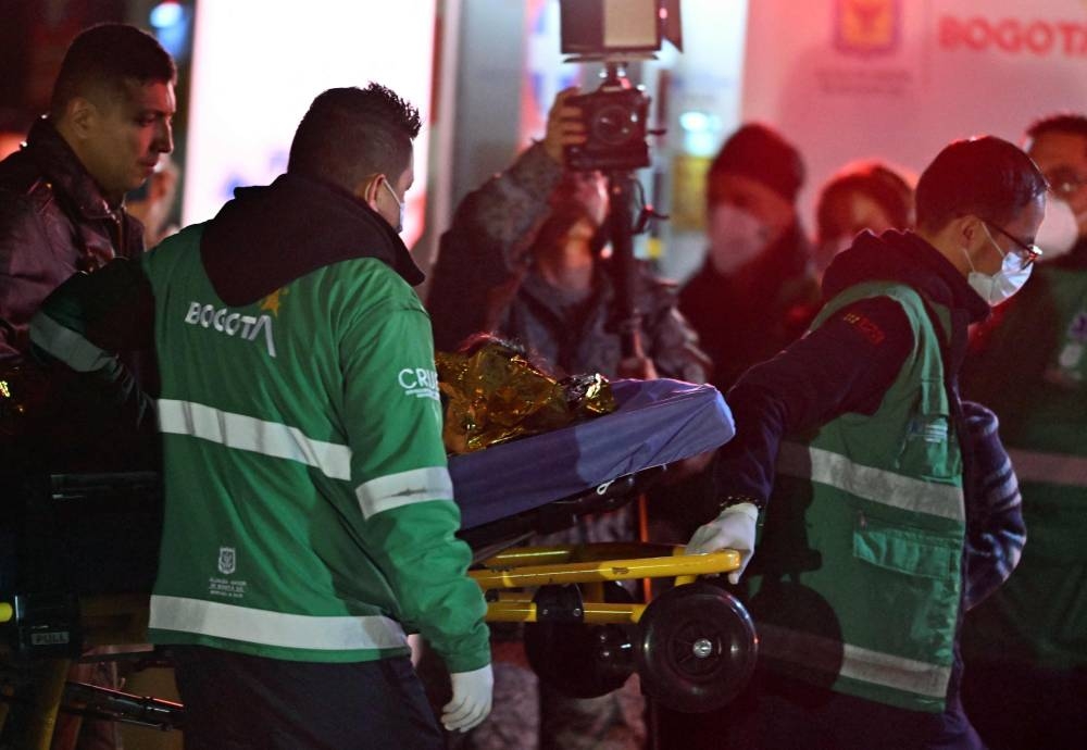 One of the four Indigenous children who were found alive after being lost for 40 days in the Colombian Amazon forest following a plane crash, is stretchered to an ambulance upon landing at the CATAM military base in Bogota. AFP