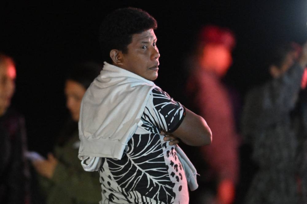 Manuel Ranoque, father of the four Indigenous children who were found alive after being lost for 40 days in the Colombian Amazon forest following a plane crash, stands on the tarmac as his children are being taken into ambulances upon landing at the CATAM military base in Bogota.   AFP