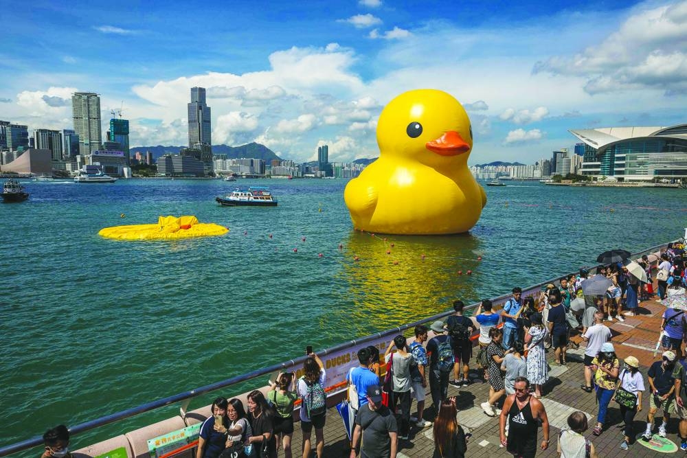 People visit the Double Ducks installation after one of the ducks deflated on Saturday.