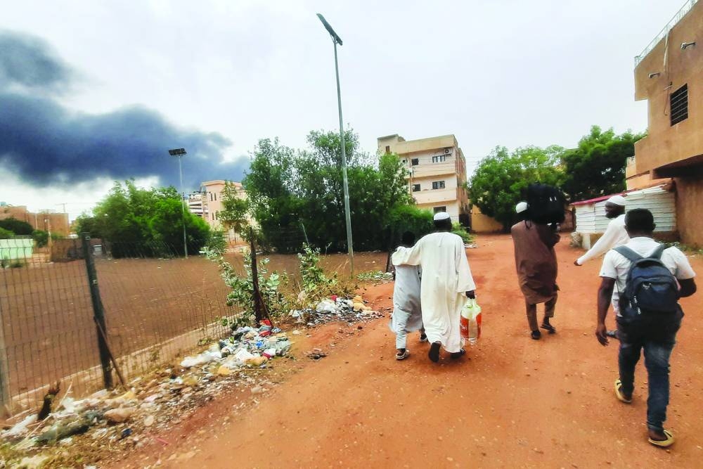 Smoke rises above buildings in Khartoum as people flee with some belongings. A 24-hour ceasefire took effect on Saturday between Sudan’s warring generals but, with fears running high that it will collapse like its iterations, US and Saudi mediators warn that they may break off mediation efforts.