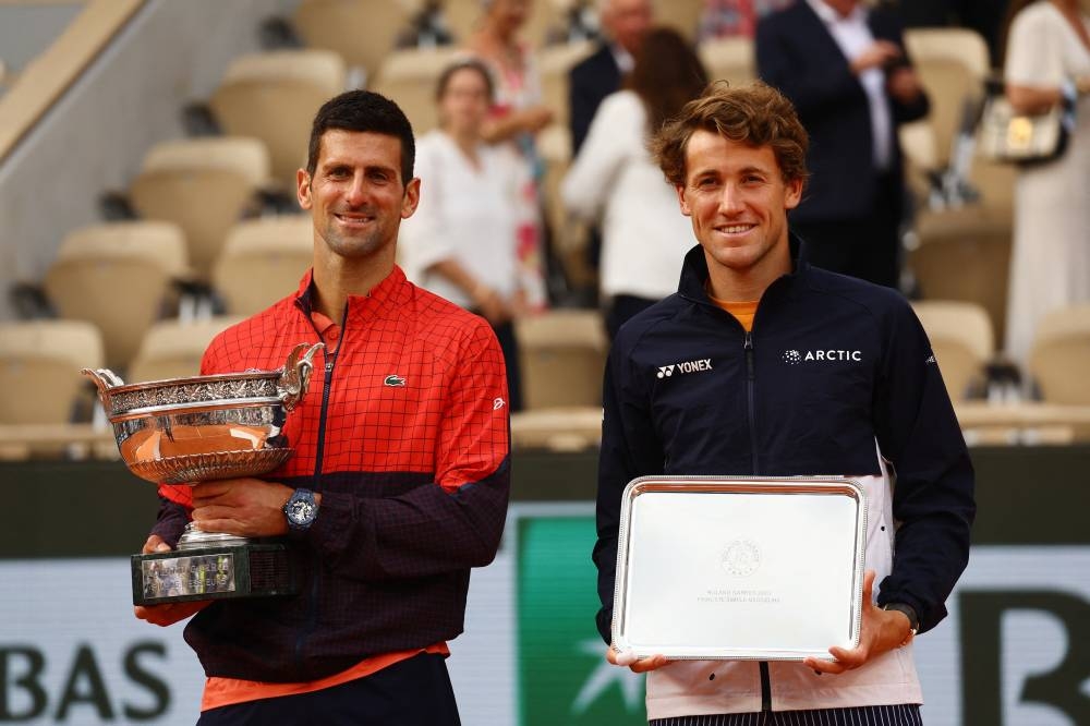 Serbia's Novak Djokovic and Norway's Casper Ruud pose with their trophies after their final match. REUTERS/Kai Pfaffenbach