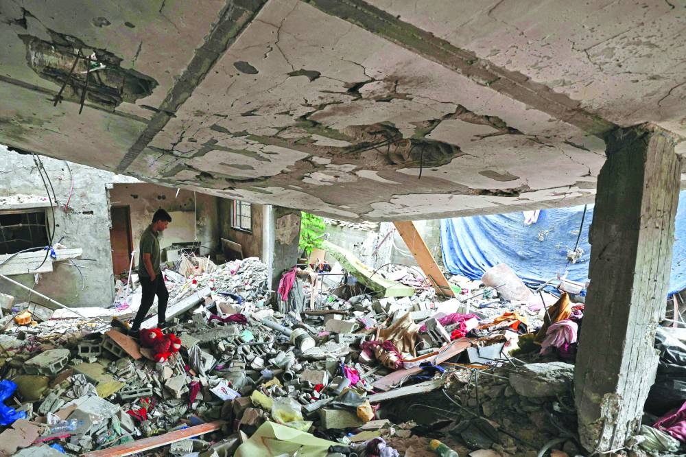 A Palestinian man walks in his destroyed house in Gaza City which was hit during the latest round of fight between Gaza fighters and the Israeli army, on Tuesday.
