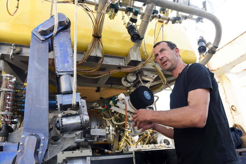 (FILES) IFREMER employee and technician responsible for the underwater robot "Victor", Luc Taillez stands next to to the robot aboard the "Thalassa", the ship of French Research Institute for the Exploitation of the Sea (IFREMER), moored at Brest harbour, western France, on August 31, 2022. The French research ship Atalante deployed the unmanned robot on Thursday in the search to find the missing submersible "Titan" near the Titanic wreck, the US Coast Guard tweeted. Experts have called the Victor 6000 "the main hope" for an underwater rescue. (Photo by Sebastien SALOM-GOMIS / AFP)