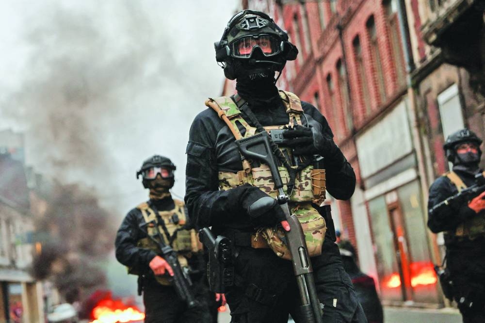 
Officers stand guard during riots in Lille yesterday. 
