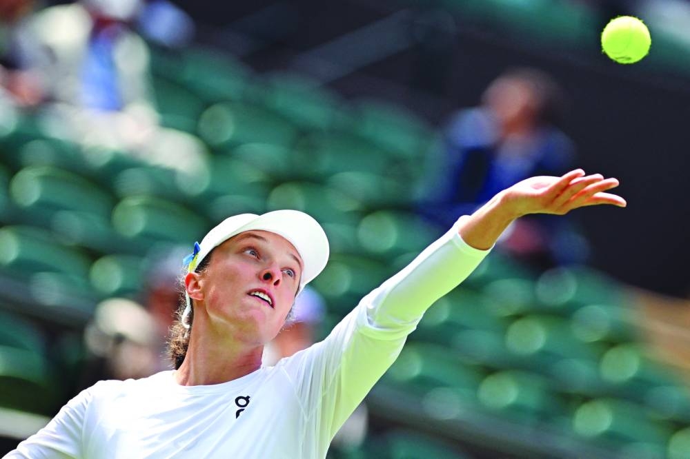 Poland’s Iga Swiatek serves to China’s Zhu Lin during their match on Monday. (AFP)