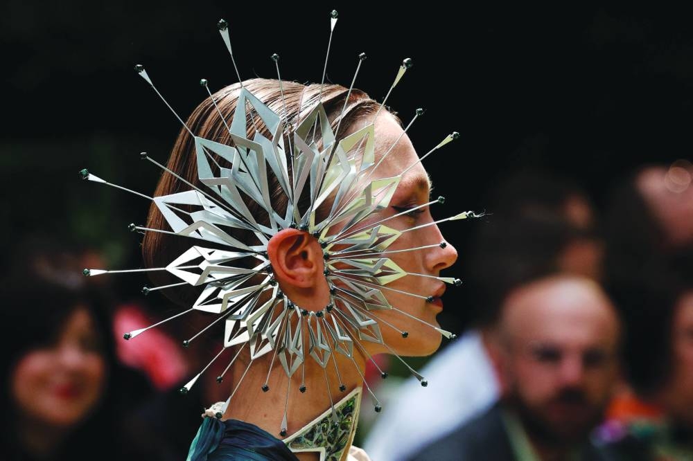 A model presents a creation by Dutch fashion designer Iris Van Herpen (left) and models present creations by Christian Dior during the Women’s Haute-Couture Fall/Winter 2023/2024 Fashion Week in Paris on Monday. (AFP)